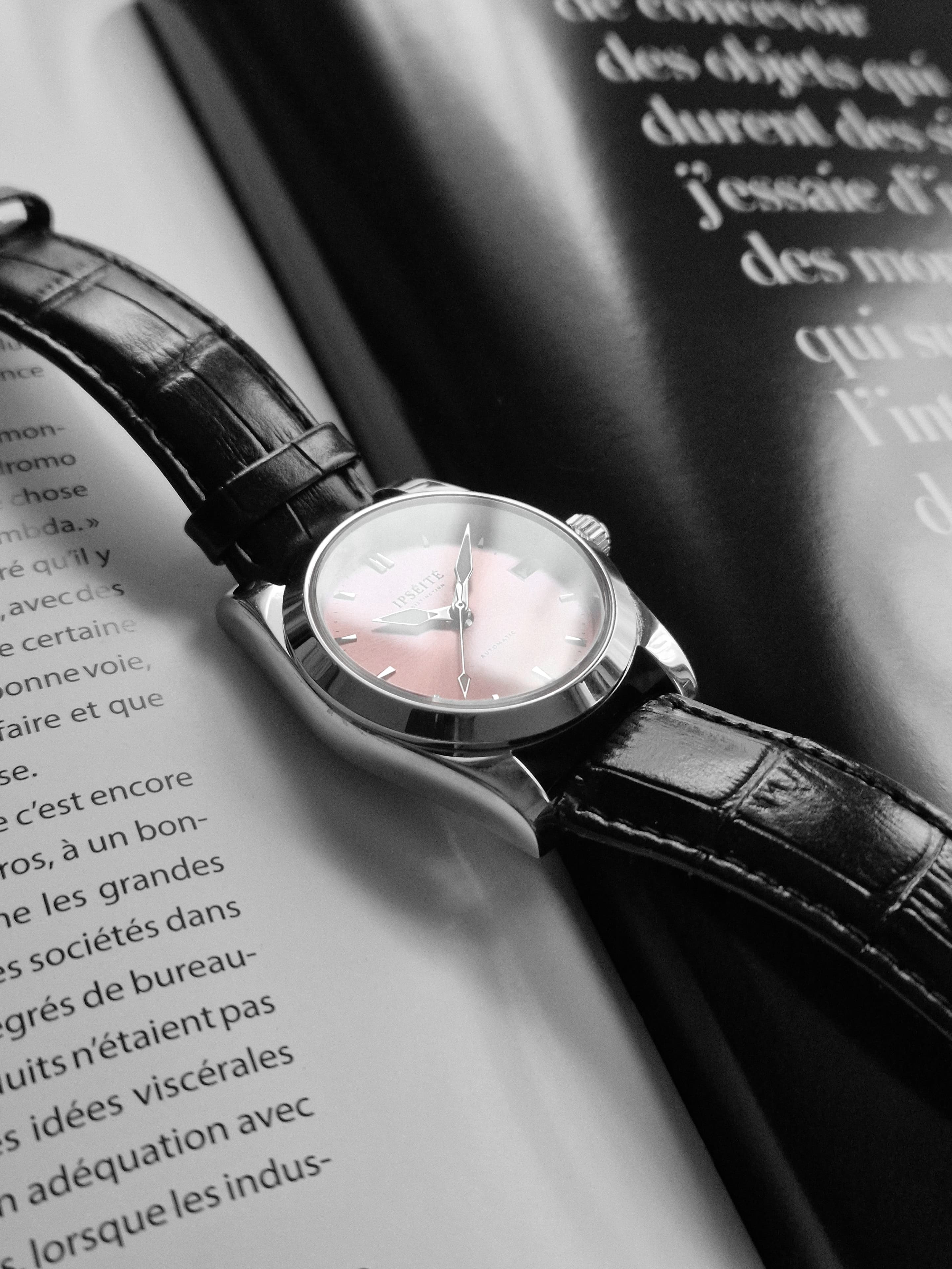 Distinction cadran rose posée sur un magazine